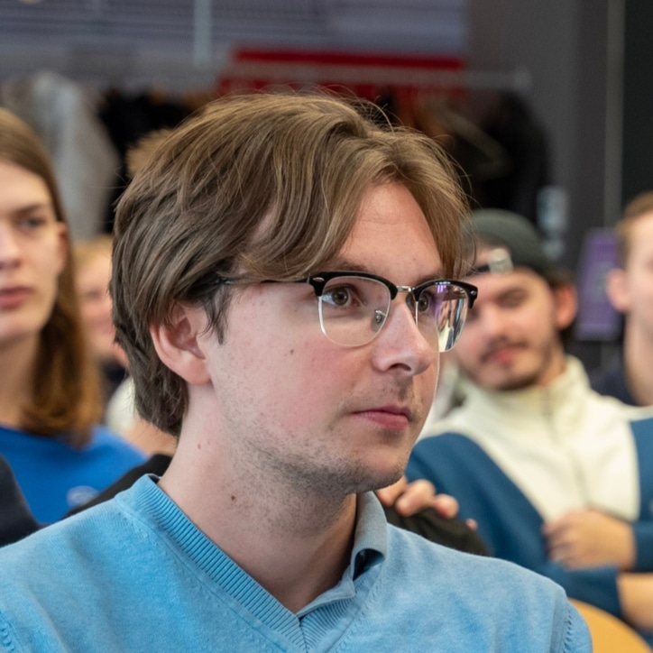 Santino Schrader smiling sitting with a group of people
